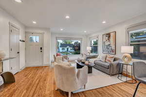 Living room with light wood-style flooring, plenty of natural light, and recessed lighting