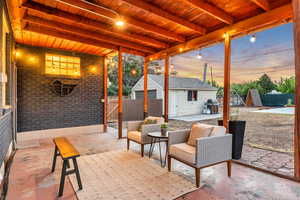 Patio terrace at dusk featuring a patio area, an outdoor structure, grilling area, and an outdoor living space