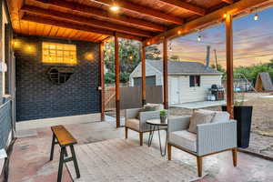 Patio terrace at dusk with a patio, an outbuilding, and a grill