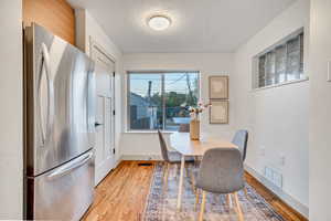 Dining space featuring light wood-style floors and a textured ceiling