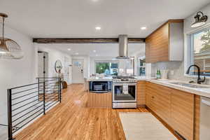 Kitchen featuring plenty of natural light, tasteful backsplash, light wood-type flooring, a peninsula, and recessed lighting