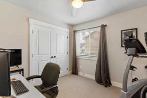 Office space featuring light colored carpet and a ceiling fan