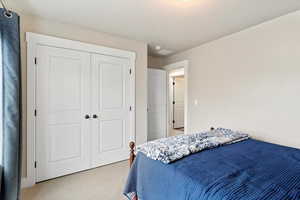 Carpeted bedroom featuring a closet