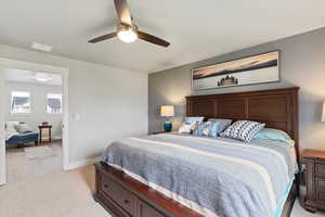 Bedroom with light carpet and a ceiling fan