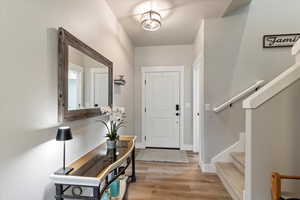 Entryway with light wood-type flooring and stairway