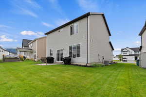 Back of house with a patio and a lawn