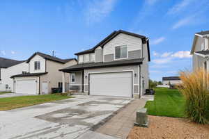 Traditional home with driveway, a garage, and a front yard