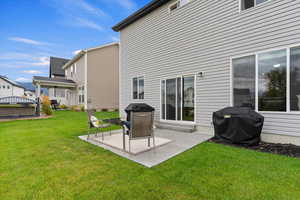 Rear view of house featuring a patio and a yard