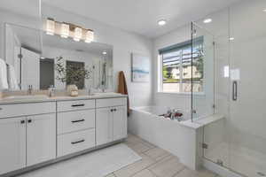 Primary Bathroom with a stall shower, a bath, double vanity, and recessed lighting