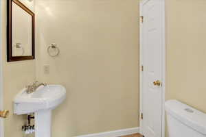 Half bath with toilet and baseboards