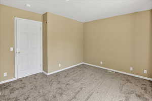 Carpeted spare room with baseboards