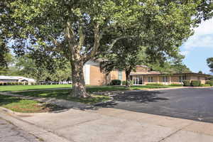 View of front facade with a front lawn and brick siding