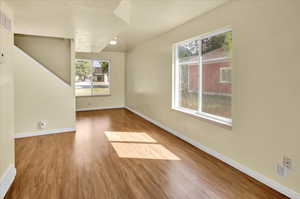 Unfurnished living room with baseboards and wood finished floors