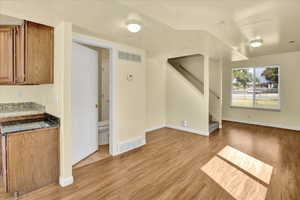 Unfurnished living room with stairs and light wood finished floors