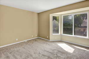 Empty room featuring carpet and baseboards