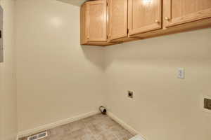 Washroom featuring cabinet space and electric dryer hookup