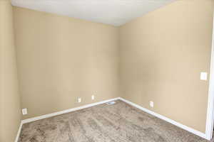 Empty room featuring carpet floors and baseboards