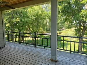 Deck featuring ceiling fan and a yard