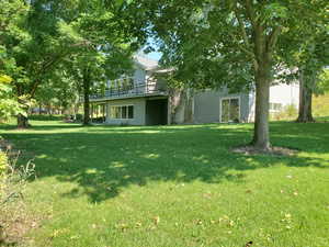 View of grassy yard featuring a wooden deck