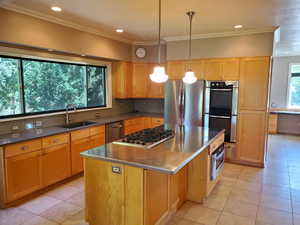 Kitchen with stainless steel appliances, light tile patterned floors, a center island, backsplash, and recessed lighting