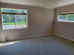 Carpeted spare room featuring ornamental molding and recessed lighting