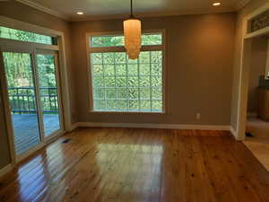 Unfurnished dining area featuring light wood-type flooring, crown molding, and recessed lighting