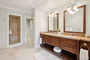 Bathroom featuring double vanity, a stall shower, and ornamental molding