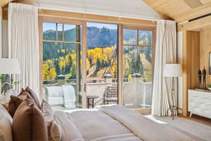 Bedroom with vaulted ceiling, a mountain view, access to outside, wood ceiling, and wood finished floors