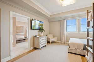 Sitting room with light wood-style floors and crown molding