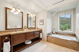Bathroom featuring double vanity, a garden tub, and recessed lighting
