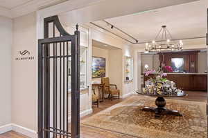 Foyer featuring crown molding, light wood-type flooring, and a chandelier