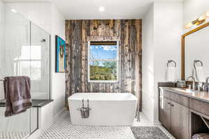 Bathroom with a stall shower, vanity, and a freestanding bath