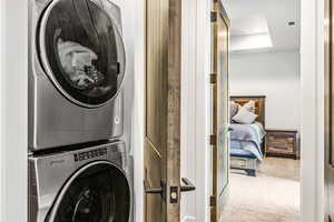 Washroom featuring carpet flooring, stacked washer / dryer, and recessed lighting