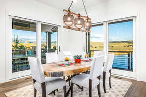 Dining area with hardwood / wood-style floors and a chandelier