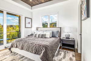 Bedroom with access to outside, wood finished floors, wooden ceiling, and recessed lighting