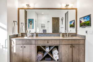 Bathroom featuring a shower stall and double vanity