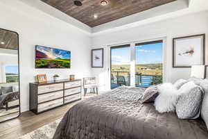 Bedroom with wooden ceiling, access to outside, light wood-style floors, recessed lighting, and a raised ceiling