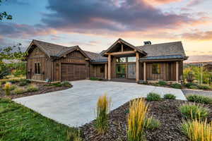 View of front of property featuring concrete driveway, an attached garage, and board and batten siding