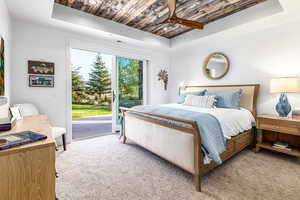 Carpeted bedroom featuring a raised ceiling, wood ceiling, access to exterior, a ceiling fan, and recessed lighting