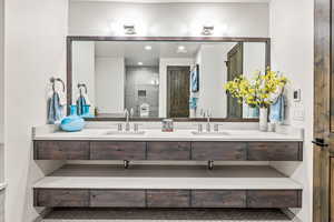 Bathroom with double vanity, recessed lighting, light tile patterned flooring, and tiled shower