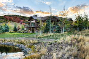 Back of property featuring a standing seam roof, a metal roof, and stone siding