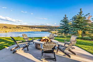 View of patio with a water view and a fire pit