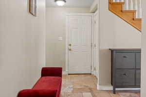 Doorway featuring baseboards and stone tile floors