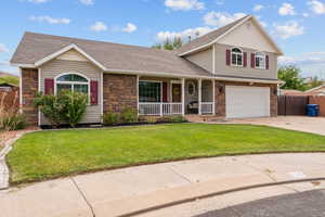 View of front of home featuring stone siding, a porch, and roof with shingles