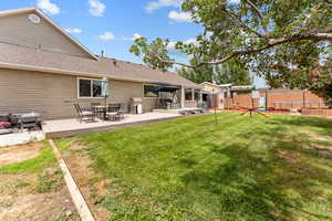 Back of house featuring a playground, a shingled roof, outdoor dining area, a deck, and a patio area