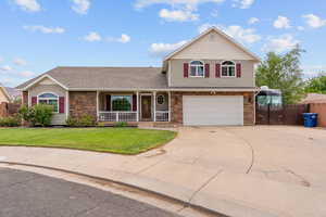 View of front of home with a porch, stone siding, concrete driveway, an attached garage, and a gate