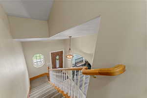 Stairway featuring a textured wall and baseboards