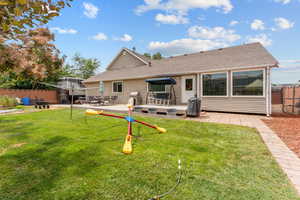 Back of property with a patio area, a shingled roof, and a trampoline