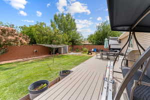 Wooden terrace featuring a fenced backyard, outdoor dining space, and area for grilling