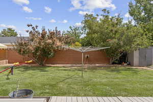 Fenced backyard featuring a storage shed